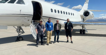 The Falcon STC install team of four, standing in front of an aircraft on the tarmac