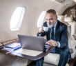 A passenger using a laptop in a business jet