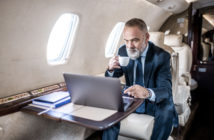 A passenger using a laptop in a business jet