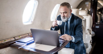 A passenger using a laptop in a business jet