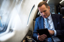 A passenger using a tablet in a business jet