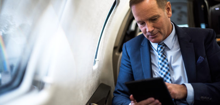 A passenger using a tablet in a business jet