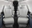 The interior of the Citation 750 overhauled by Duncan Aviation – featuring grey seats with quilted double-stitched diamond pattern inserts; navy lower sidewalls; black composite ebony veneer; satin chrome plating; and a dark carpet with light accents