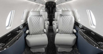 The interior of the Citation 750 overhauled by Duncan Aviation – featuring grey seats with quilted double-stitched diamond pattern inserts; navy lower sidewalls; black composite ebony veneer; satin chrome plating; and a dark carpet with light accents