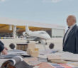 Kadri Muhiddin and Waleed Muhiddin of AMAC Aerospace in conversation over a table of material/design samples with a hangar and aircraft in the background