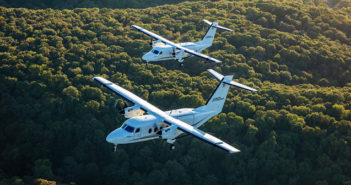 The Cessna SkyCourier flying over a forest