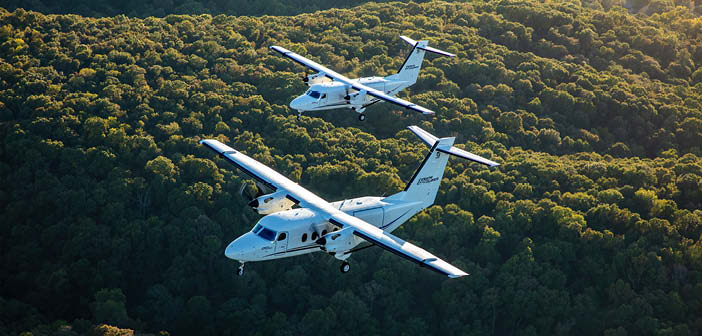The Cessna SkyCourier flying over a forest