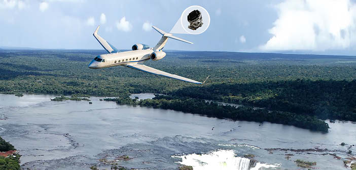Business jet flying over landscape, with cutout of installed equipment