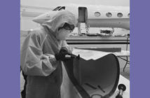 Technician working on a component with aircraft in background