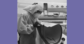 Technician working on a component with aircraft in background