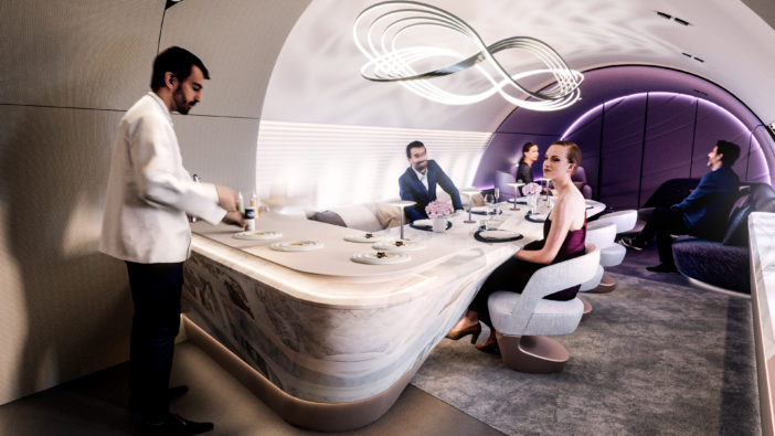 VIP aircraft cabin with chef cooking for passengers at a table