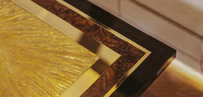 Close up of table with textured and smooth brass and veneer