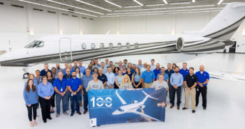 Group photo in front of business jet in hangar