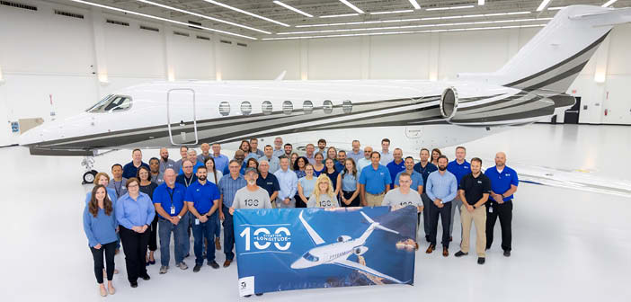 Group photo in front of business jet in hangar