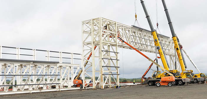 Cranes lifting frame structure into place