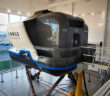 A simulator is sitting in a room with a lot of windows